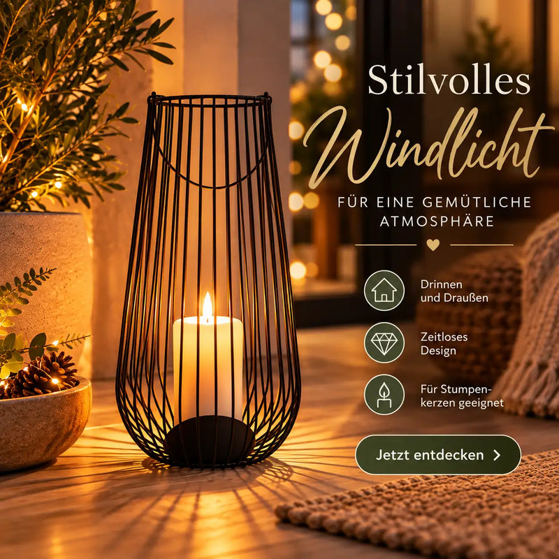 Schwarzes Drahtgitter-Windlicht mit einer beleuchteten weißen Kerze im Inneren